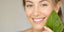 Woman with glowing skin holding a plant.